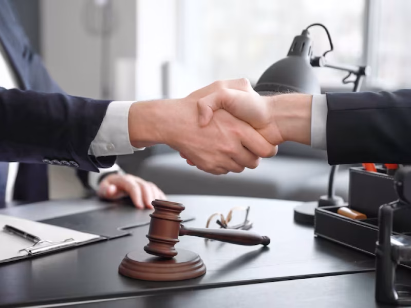 male-lawyer-with-client-shaking-hands-office_392895-12430